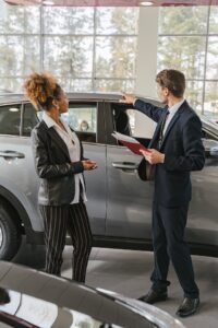 Man and woman looking at car.