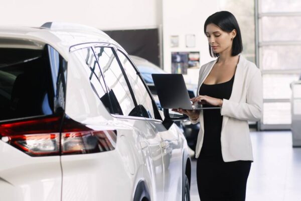 Dealership salesperson checking tablet.