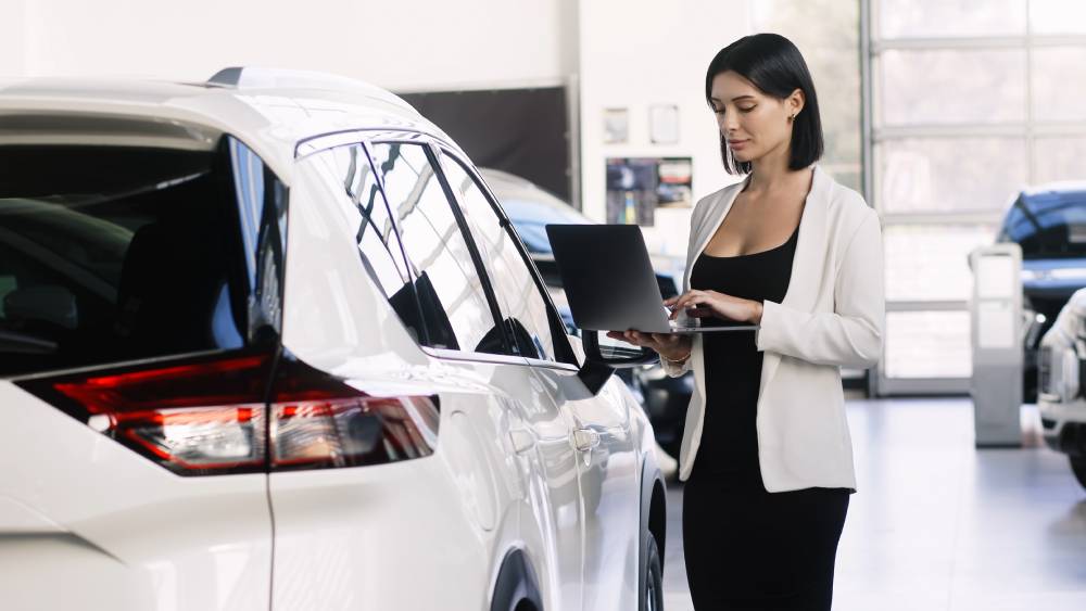 Dealership salesperson checking tablet.